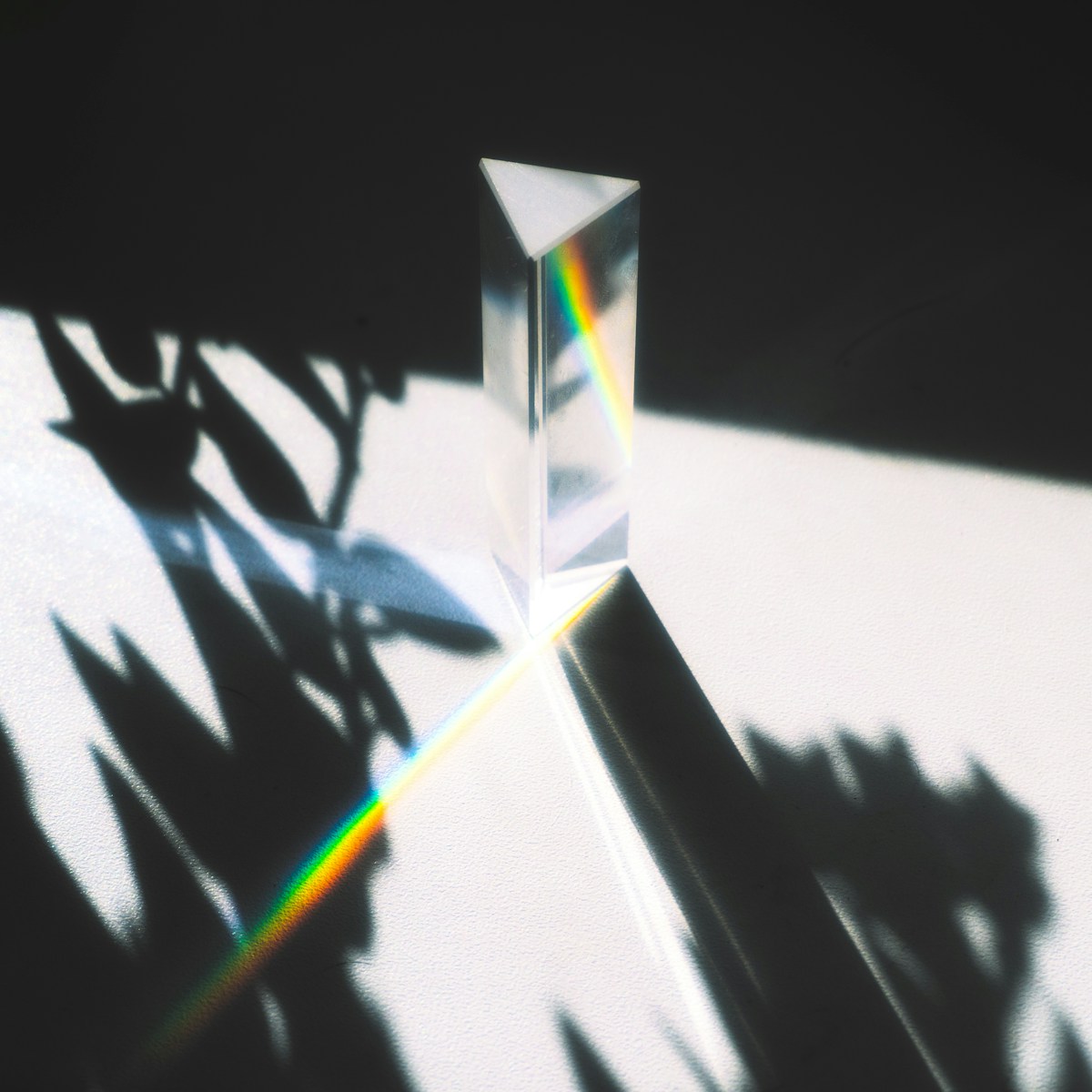 A glass prism revealing a rainbow spectrum in sunlight.